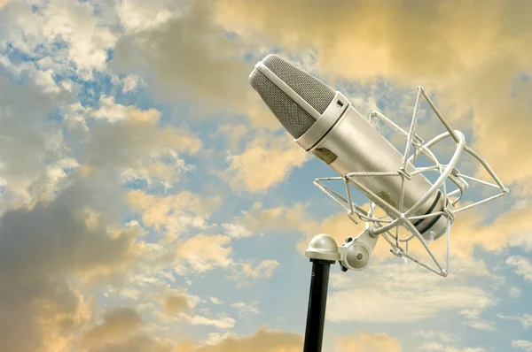Klasik mikrofon ve bulutlu gökyüzü — Stok fotoğraf