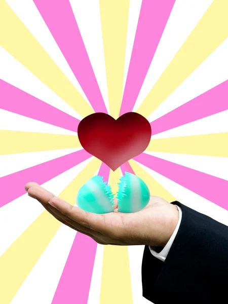 Ovo de Páscoa com coração vermelho na mão de homem de negócios — Fotografia de Stock