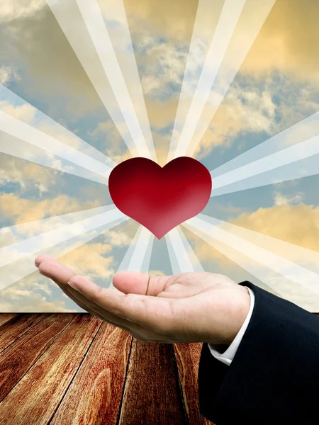 Красное сердце на руке бизнесмена — стоковое фото