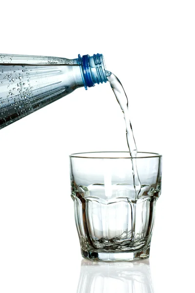 Frischwasser wird in leeres Glas gegossen — Stockfoto