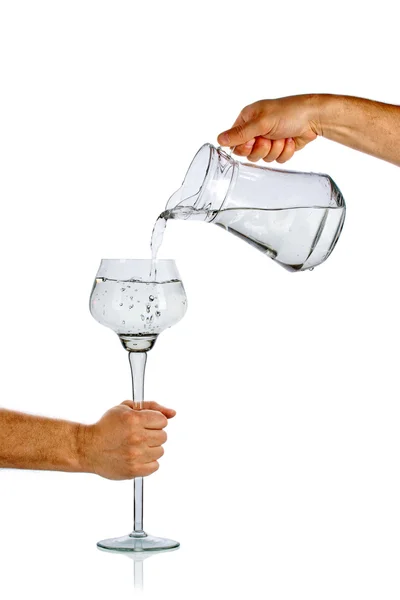 Hand pouring water from glass jug — Stock Photo, Image