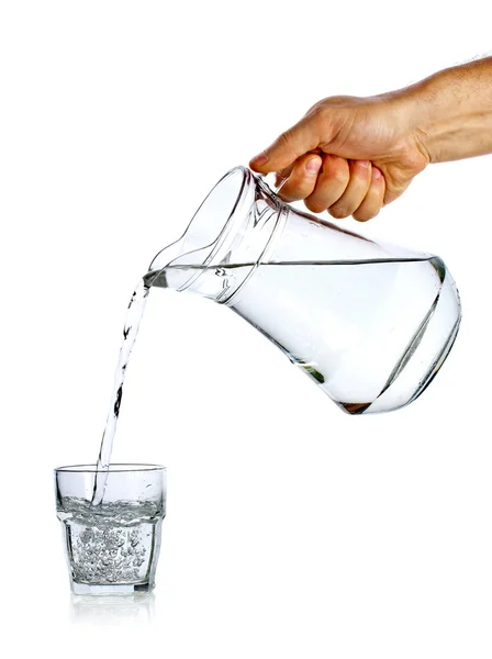 Mano vertiendo agua de jarra de vidrio — Foto de Stock