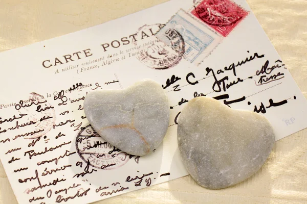 Corazones de piedra con postal — Foto de Stock