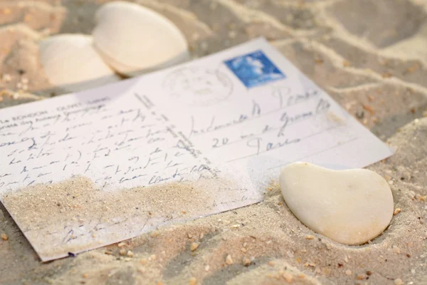 Srdce s pohlednice v písku — Stock fotografie