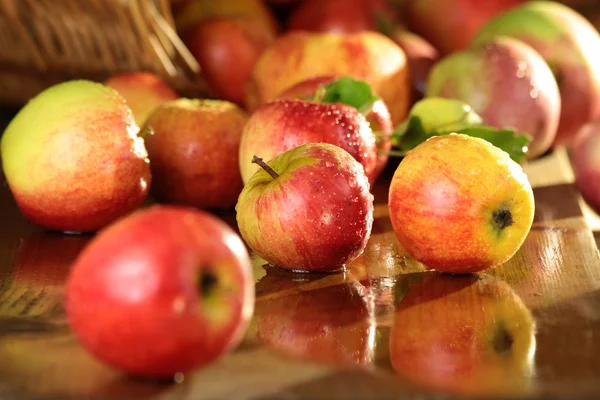 Basket of apples on a wet table — Stock Photo, Image