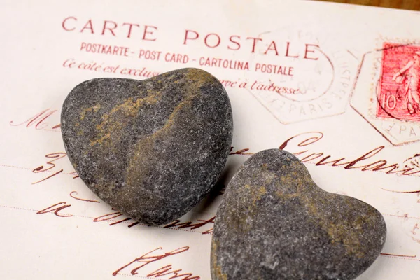 Corazones de piedra con postal — Foto de Stock