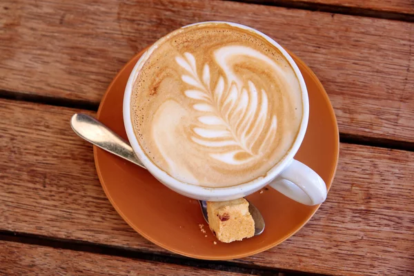 Cappuccino avec symbole de feuille sur une table en bois — Photo