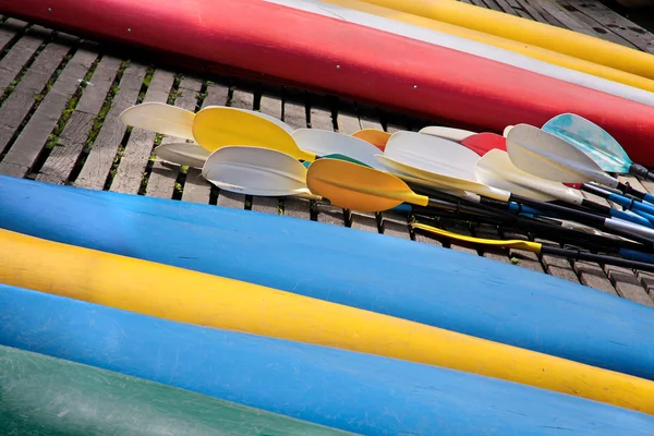 Omgekeerde kleurrijke kajaks en roeien op de oever — Stockfoto