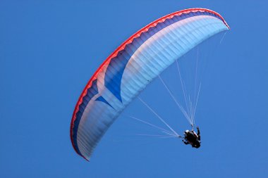 Paraglider in blue sky clipart