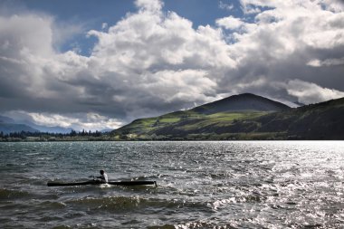 Oarsman on Lake Hayes on a stormy day clipart