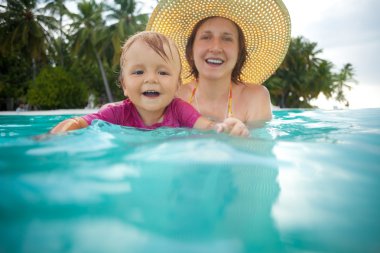 Kid swimming with mothers help clipart