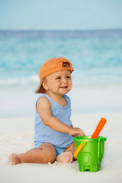 Kid playing with sand on the beach — Stock Photo, Image