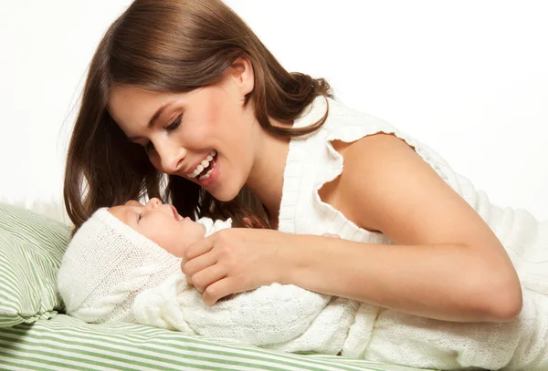Bebek yatakta ile oynarken annesi — Stok fotoğraf