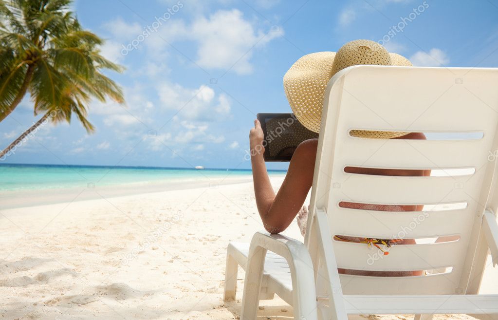 Woman with tablet computer on the beach