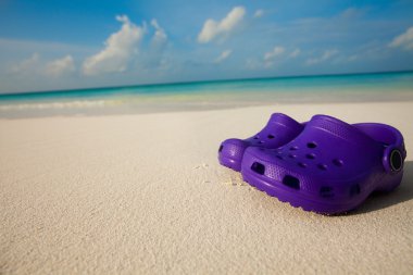 Kids shoes on the beach clipart