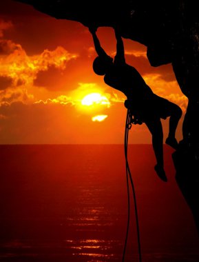 Rock climbing during sunset clipart