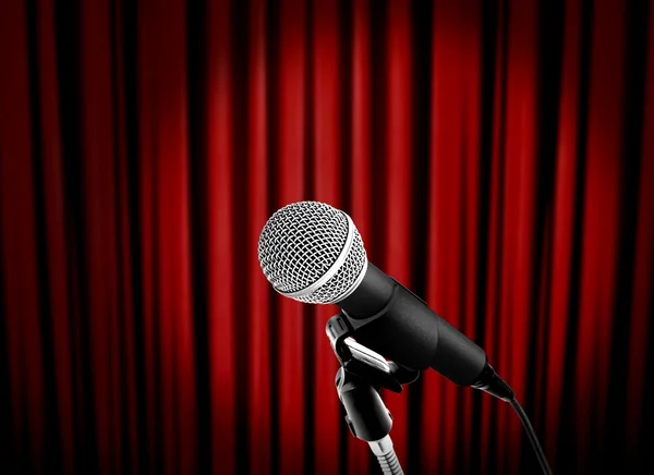 Микрофон на сцене с красным занавесом — стоковое фото