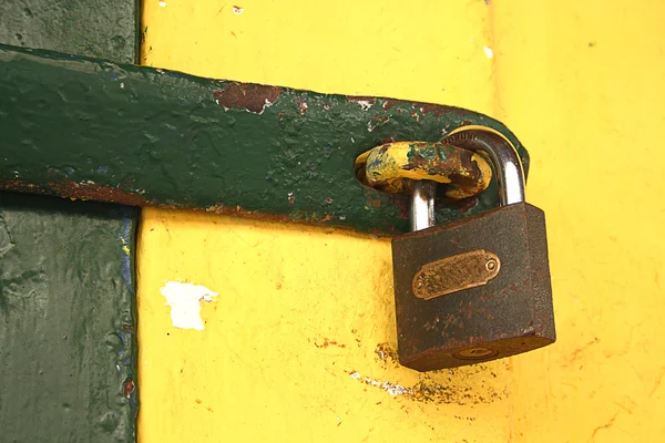 黄墙上的旧生锈的挂锁 — 图库照片