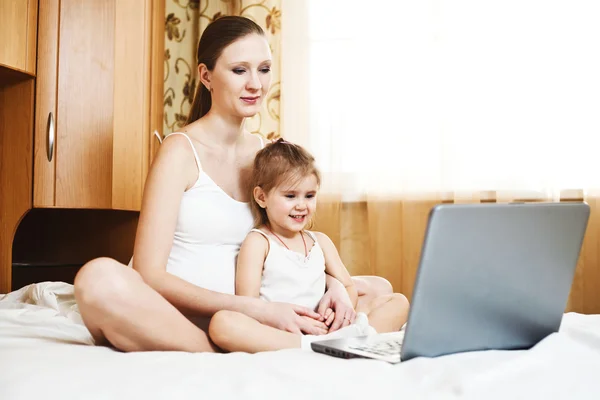 Feliz madre embarazada y el niño con el ordenador portátil — Foto de Stock