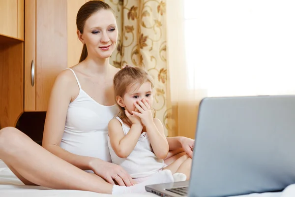 Madre incinta e bambino con computer portatile — Foto Stock