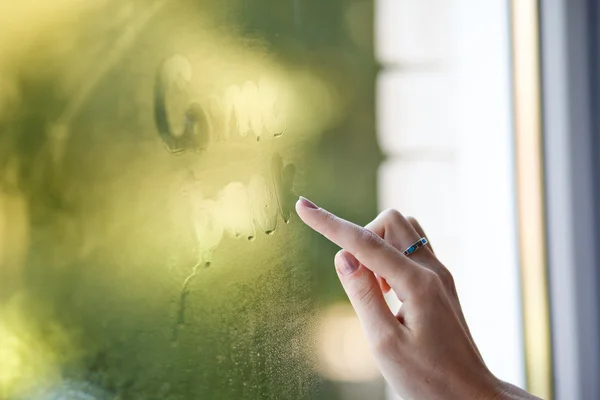 stock image A hand writing on window