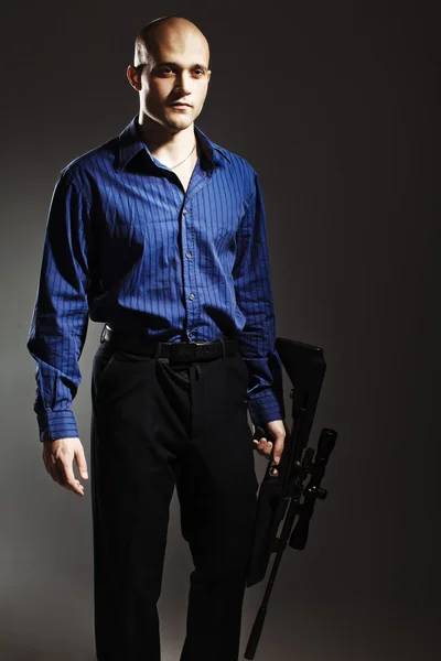 Handsome young man holding a gun — Stock Photo, Image