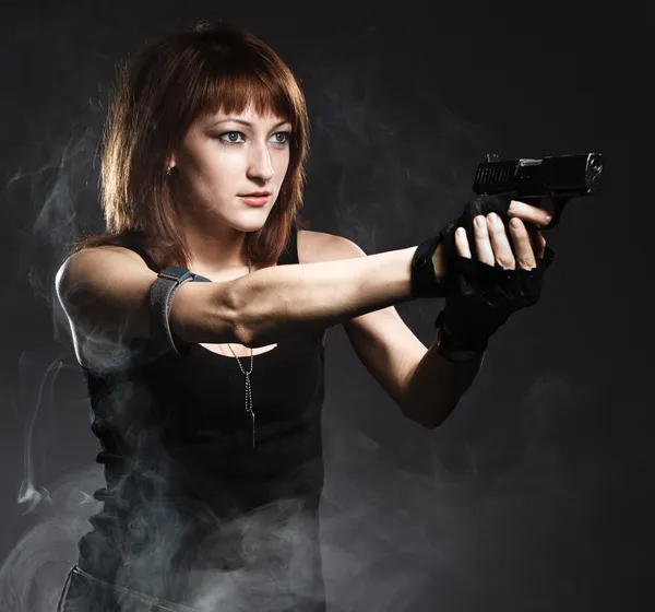 Жінка тримає пістолет з димом — стокове фото
