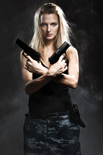 Vrouw bedrijf pistool met rook — Stockfoto