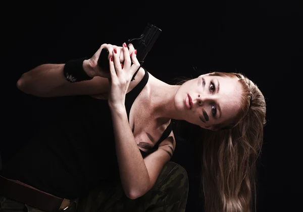 Woman holding gun on dark — Stock Photo, Image