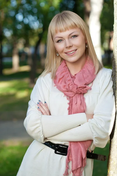 Smilng blonde vrouw in de buurt van boom — Stockfoto