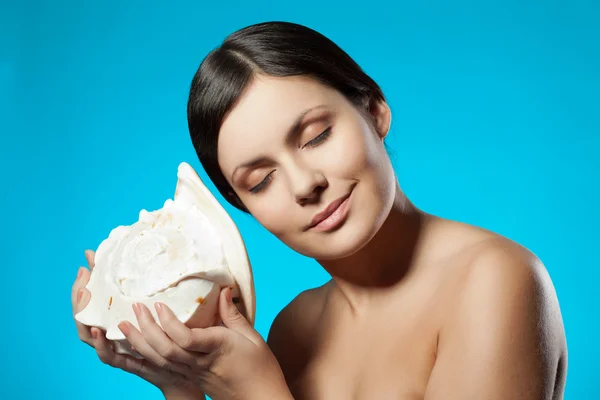 Kvinna anläggning seashell — Stockfoto