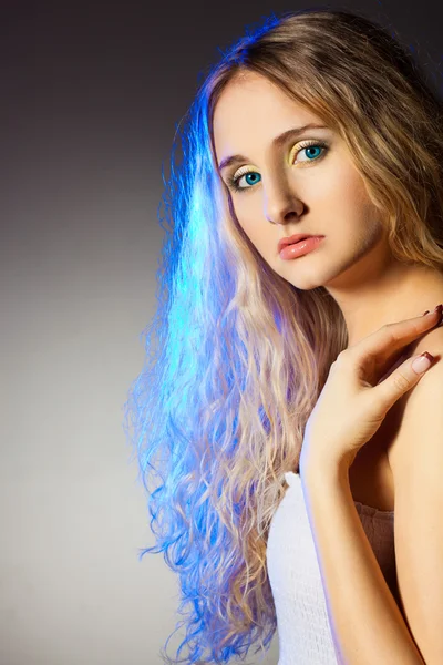 Mavi ışıklı kıvırcık saçlar kadınla — Stockfoto