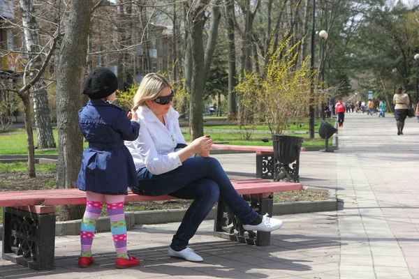 Spring. Mother and daughter on the bench. — Stock Photo, Image