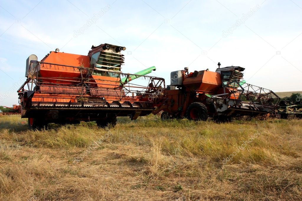 Color photo of old combine harvesters.