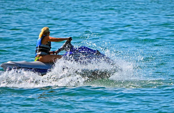 Rubia en una moto acuática azul —  Fotos de Stock
