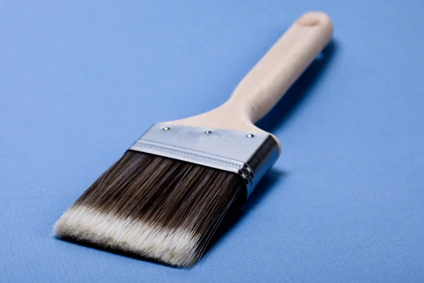 Brush on blue background — Stock Photo, Image