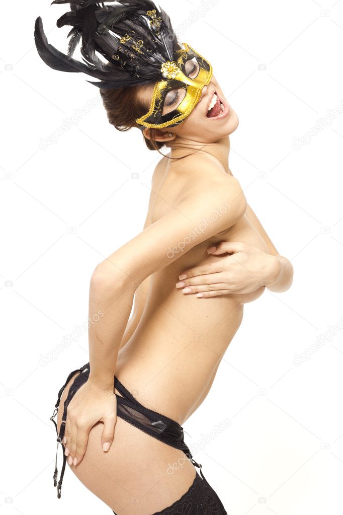 Passionate young woman in carnival mask and lingerie on white isolated background
