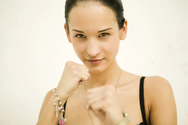 Beautiful woman doing boxing movement on white isolated background