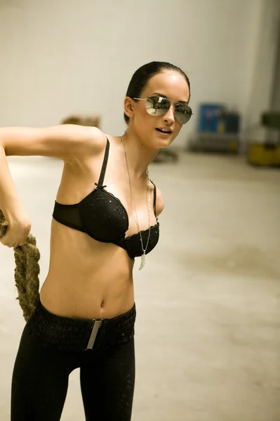 Mulher sexy em lingerie e óculos de sol no salão de fábrica — Fotografia de Stock