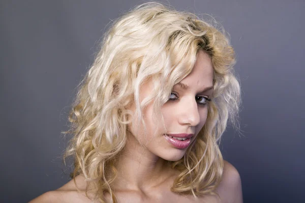 Sexy young blonde woman in gray dress in a studio — Stock Photo, Image