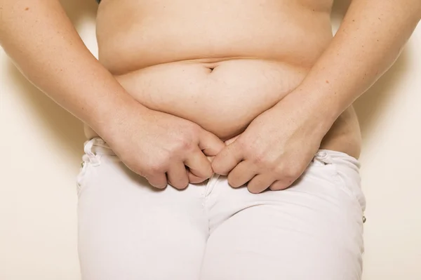Mujer gorda sosteniendo su estómago sobre fondo blanco aislado —  Fotos de Stock