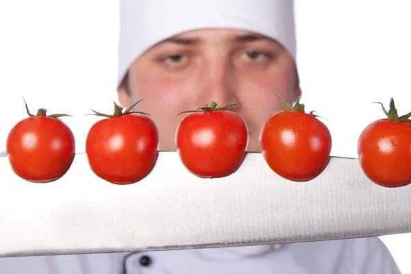 Los hombres cocinan. tomates cherry cortados en el cuchillo —  Fotos de Stock