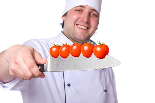 Os homens cozinham. tomates cereja cortados na faca — Fotografia de Stock