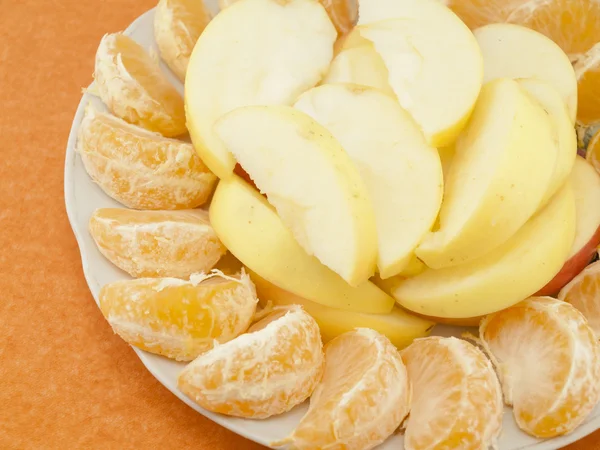 Мандарины и яблоки на тарелке — стоковое фото