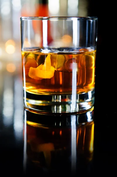 Glass of whiskey with ice cubes and fruits — Stock Photo, Image