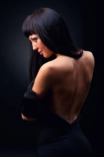 Όμορφη κομψή γυναίκα στο μαύρο φόρεμα σε εσωτερικούς χώρους — Φωτογραφία Αρχείου