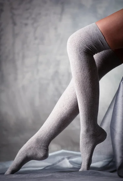 Krásná žena nohy v šedé punčochy — Stock fotografie
