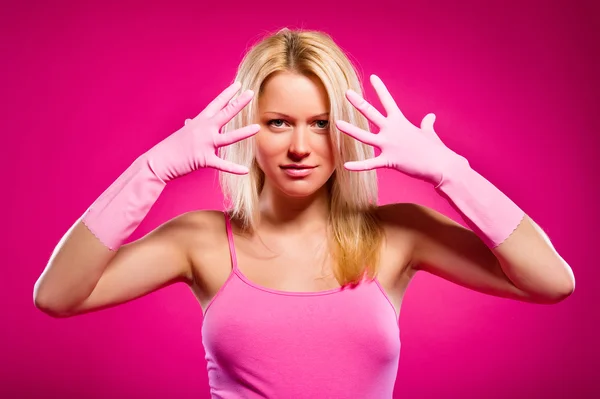 Жінка в гумових рукавичках позує над рожевим тлом — стокове фото