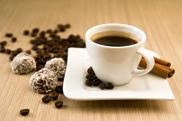 Cup of coffee with beans and truffles — Stock Photo, Image