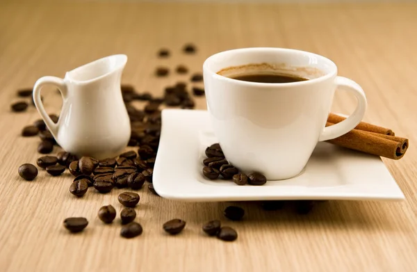 Kopp kaffe med bönor och kanelstänger — Stockfoto